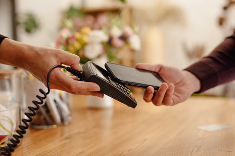 An employee taking advantage of Payhawk's automated bank reconciliation software at a vendor's office. 